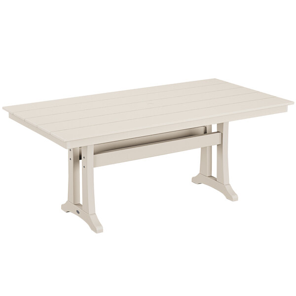 A white POLYWOOD table with wooden legs and a wooden top on a outdoor patio.
