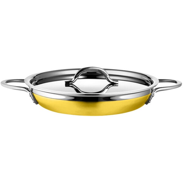 A Bon Chef stainless steel saute pan with yellow handles.