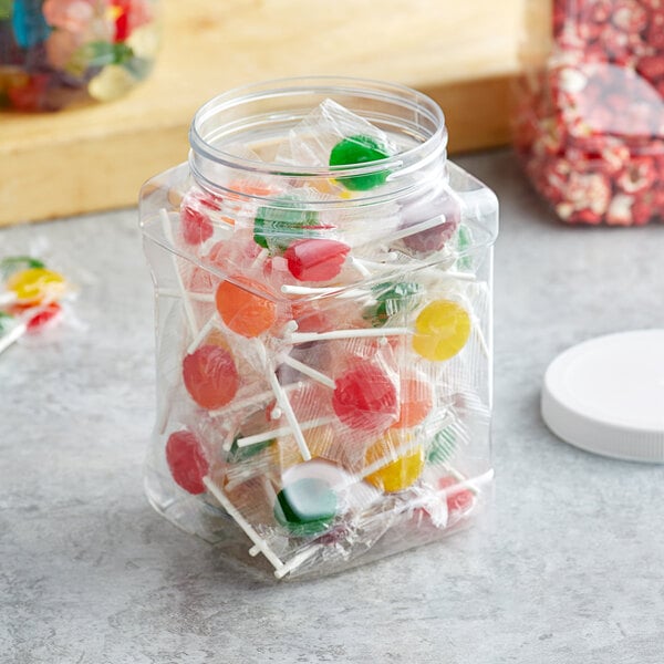 A 64 oz. Square PET plastic jar filled with lollipops and candies with a white lid.