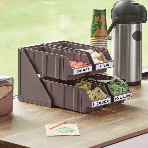 A brown 2-tier organizer with 4 bins and 2 label sheets on a counter.