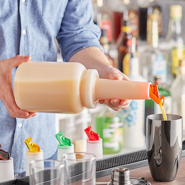 A person pouring orange liquid from a Choice pour bottle into a cup.
