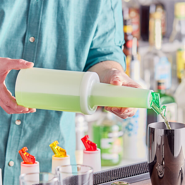 A person pouring a green drink from a white plastic Choice pour bottle with a green flip top.