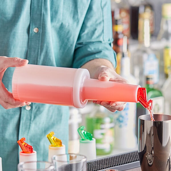 A man pouring liquid from a white Choice pour bottle into a cup on a bar counter.