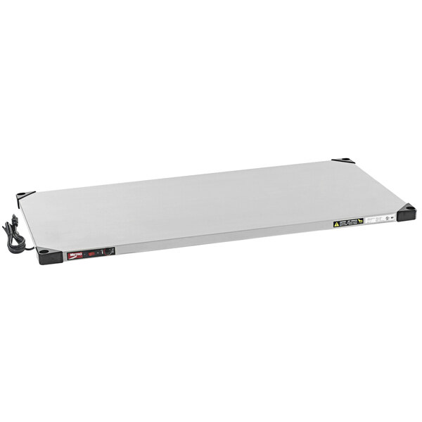 A rectangular stainless steel Metro heated shelf with black cords.