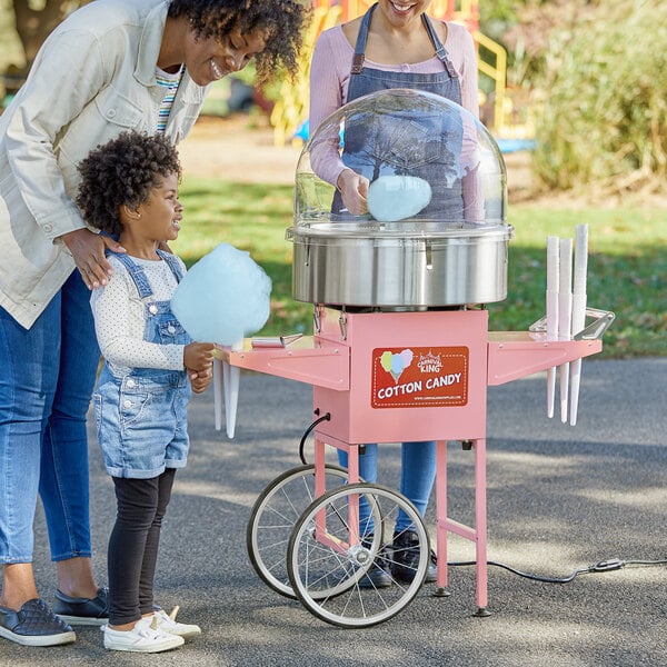 A woman and two children making cotton candy with a Carnival King cotton candy machine.