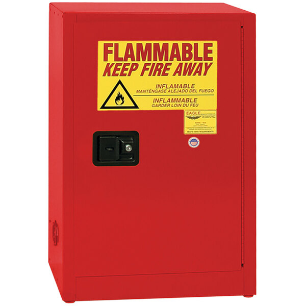A red Eagle Manufacturing safety cabinet for flammable liquids with a yellow and red sign with black text.