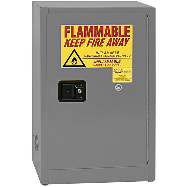 A grey metal Eagle Manufacturing safety cabinet with a yellow flammable liquid sign.