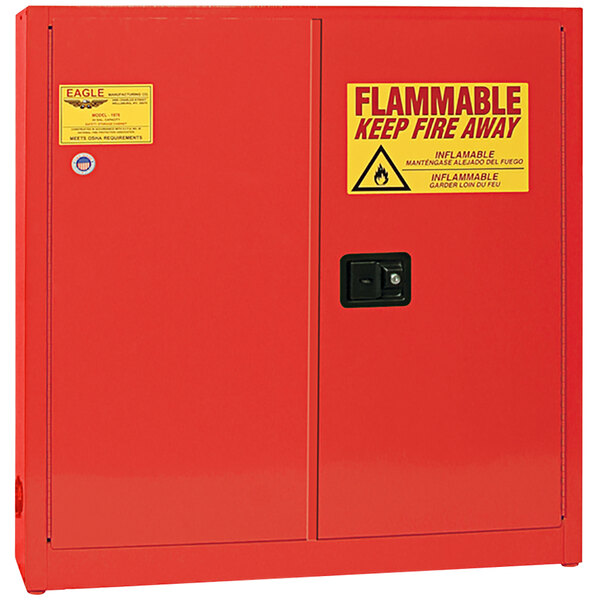A red Eagle Manufacturing safety cabinet for flammable liquids with yellow and red signs.