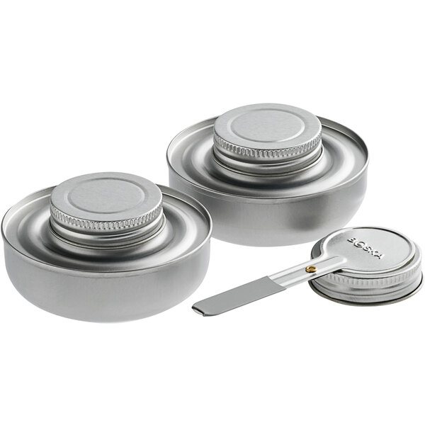 Two Boska stainless steel fondue pots with lids on a kitchen counter.