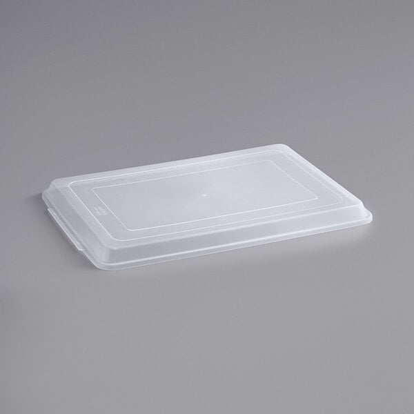 A white plastic lid on a gray surface.
