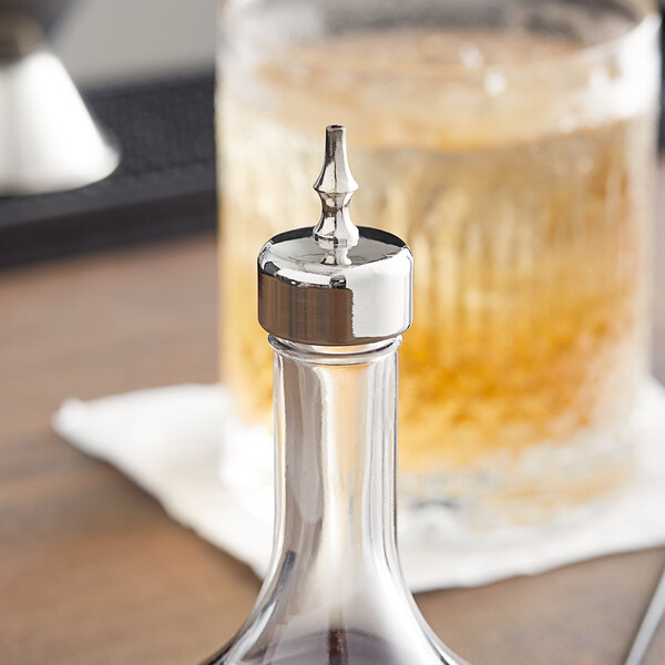 A Barfly stainless steel topped glass bitters bottle on a counter.
