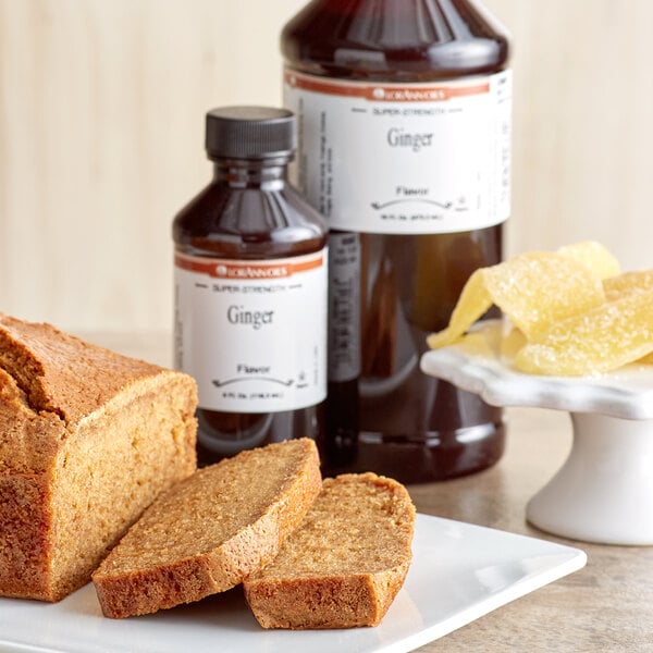 A loaf of bread and a bottle of ginger syrup on a plate.