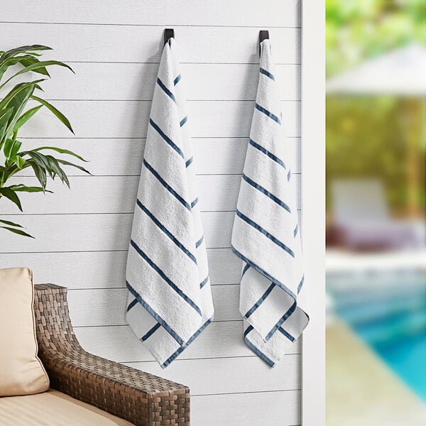 Two Monarch Brands navy striped towels hanging on a wall.
