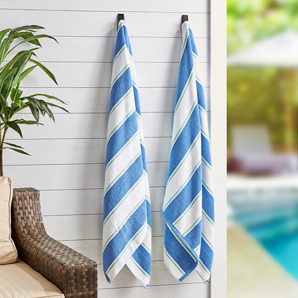 Two Monarch Brands blue and white striped towels hanging on hooks.