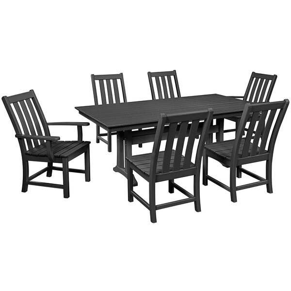 A POLYWOOD black farmhouse trestle table with six chairs on an outdoor patio.
