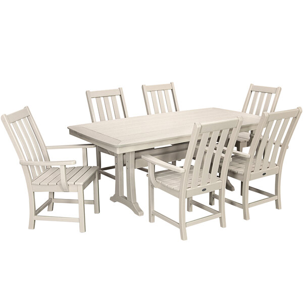 A POLYWOOD sand table with a white top and six chairs on a patio.