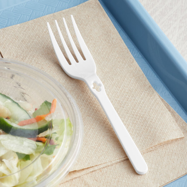 A WeGo white polypropylene fork next to a salad in a plastic container.