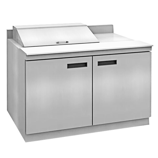 A stainless steel Delfield sandwich prep table with 4 drawers on a white counter.