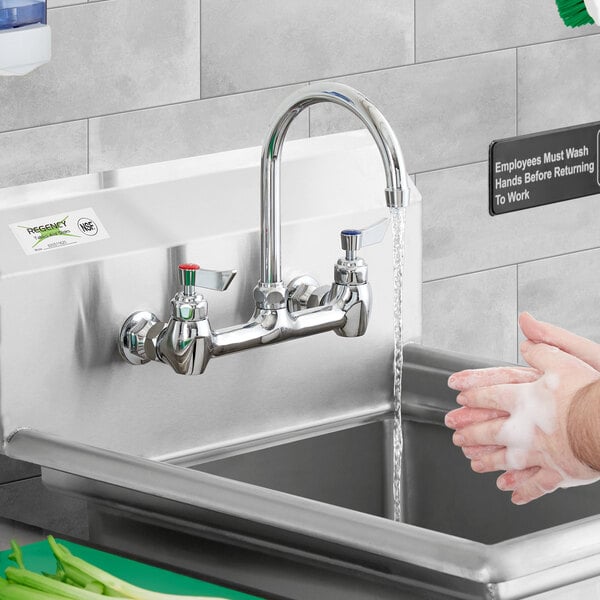 A person washing their hands under a Waterloo wall mount faucet.