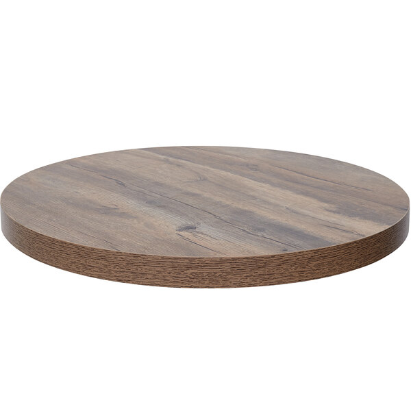 A BFM Seating Relic round knotty pine table top with a dark wood finish.
