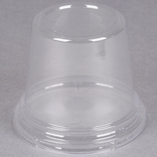 A WNA Comet clear plastic dome lid on a clear plastic cup.