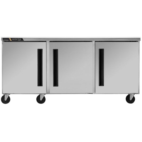 A Traulsen silver undercounter freezer with black handles and white doors.