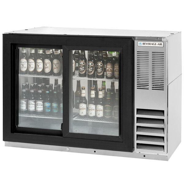 A Beverage-Air back bar refrigerator with sliding glass doors filled with beer bottles.