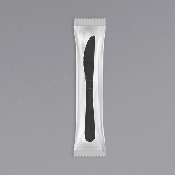 A black plastic knife in white packaging.