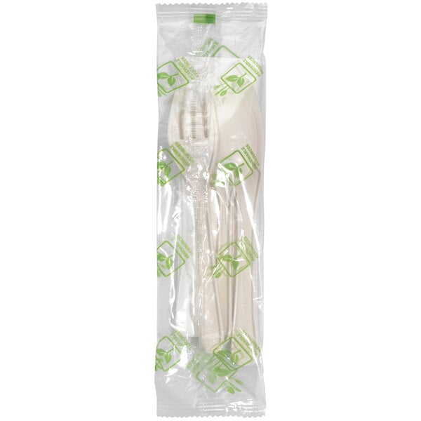 A Fineline Conserveware plastic bag with white PSM flatware and a green napkin inside.