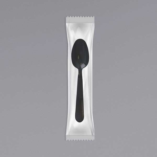 An individually wrapped black plastic spoon.