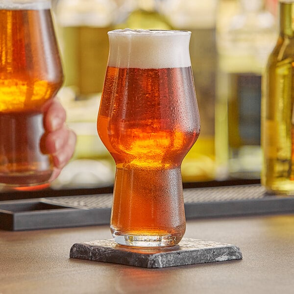 A Rastal Craft Master One beer glass full of beer on a counter.