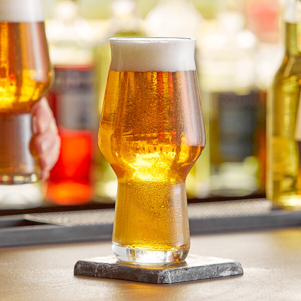 A Rastal Craft Master One beer glass full of beer on a bar counter.