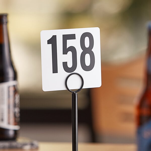 A white American Metalcraft table number card with black numbers on it.