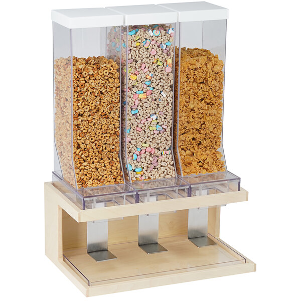 A Cal-Mil maple wood triple cereal dispenser with three containers of cereal.