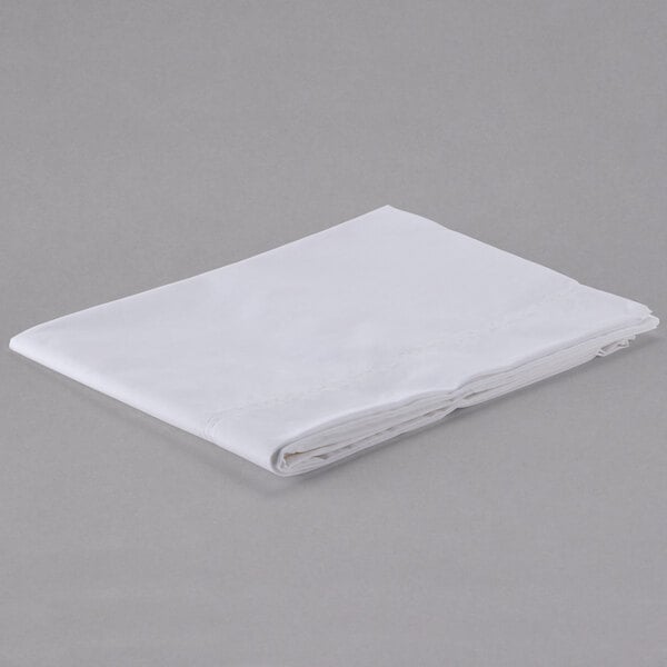A folded white Oxford Superblend satin mercerized cotton/polyester pillow case on a gray surface.