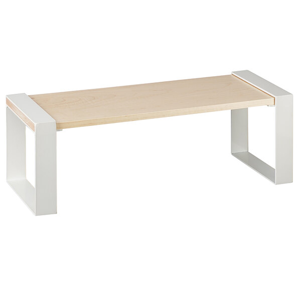 A maple wood riser with metal legs on a table.