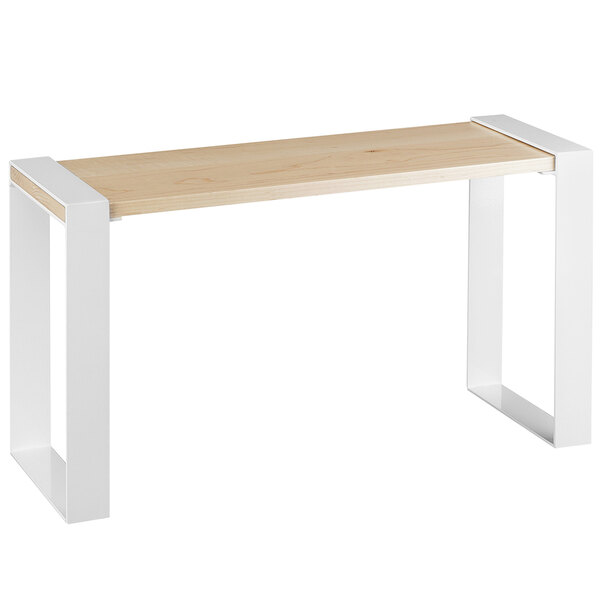 A Cal-Mil maple wood riser on a white and wood table.