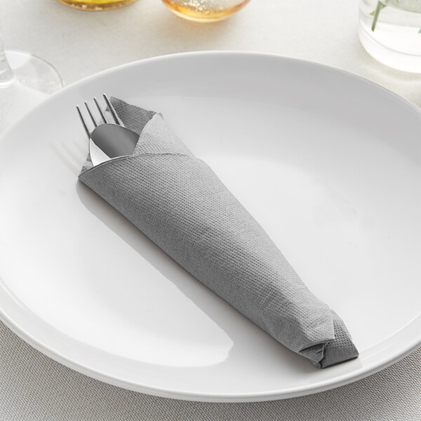 A fork and knife wrapped in a Hoffmaster FashnPoint Linen-Feel Slate dinner napkin.