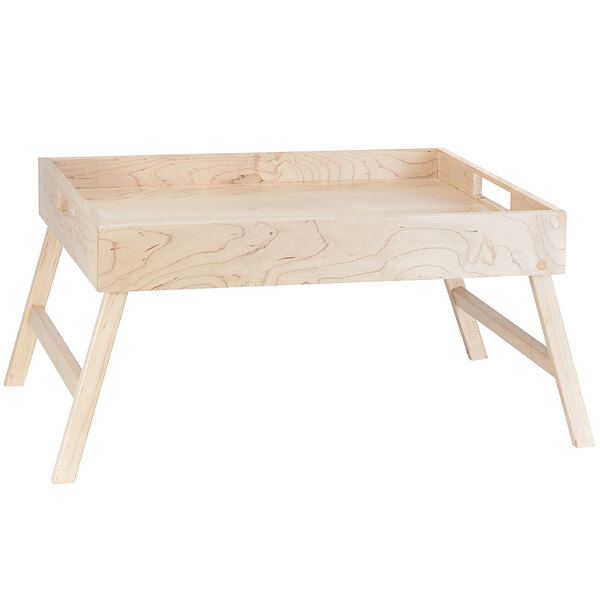 A Cal-Mil blonde maple wood room service tray with fold-out legs on a wooden table.