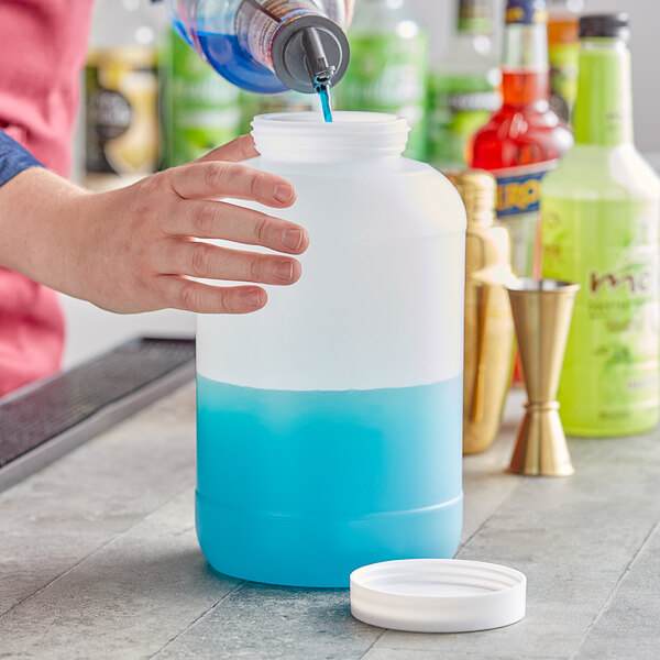 A person pouring blue liquid into a Choice plastic container.