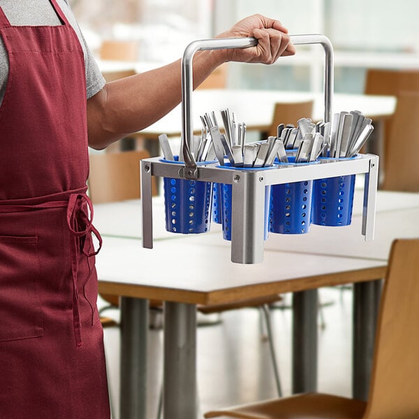 A man holding a Choice stainless steel flatware carrier with blue plastic cylinders inside.