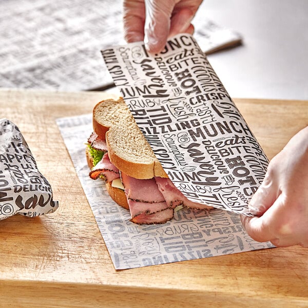 A person wrapping a Choice sandwich in deli wrap paper.