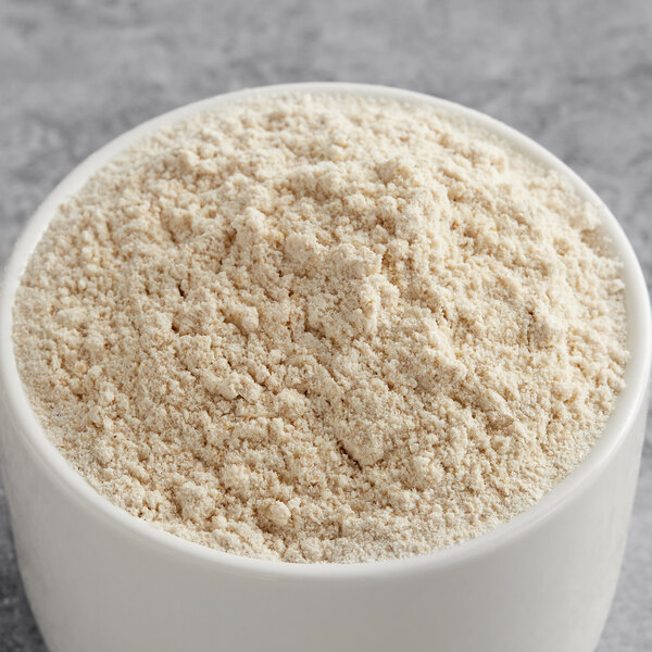 A bowl of Regal Diastatic Dry Malt Powder on a gray surface.