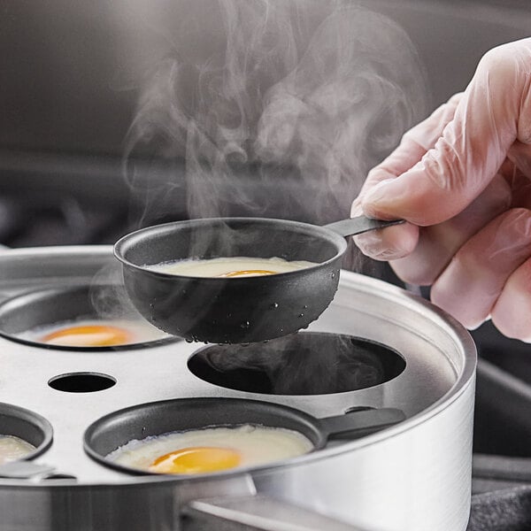 A person cooking eggs in a non-stick pan.