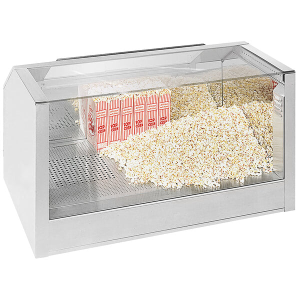 A Cretors single door counter showcase warming cabinet with popcorn and snacks displayed inside.