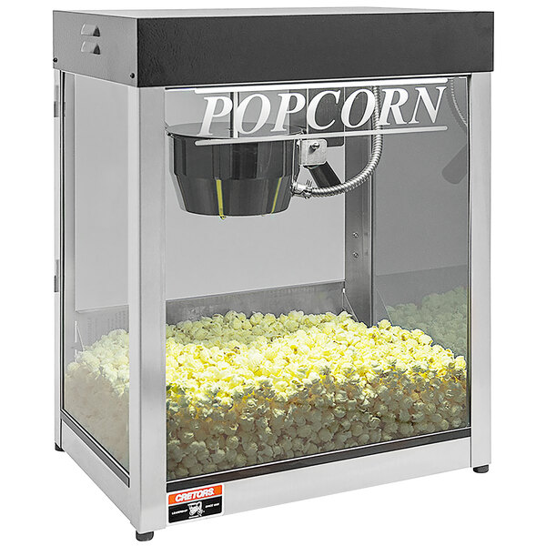 A Cretors Nite Club Black popcorn machine with popcorn in it.