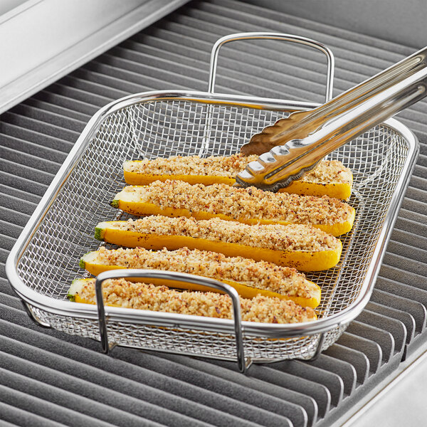 Stainless steel Outset grill basket with food on it.
