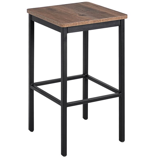 A BFM Seating black steel backless bar stool with a wood seat.