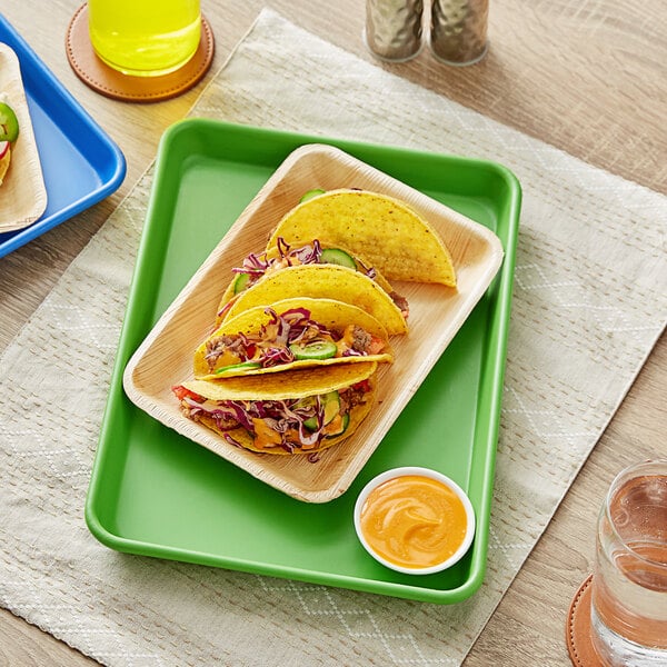 A Baker's Mark green non-stick tray with tacos on it.