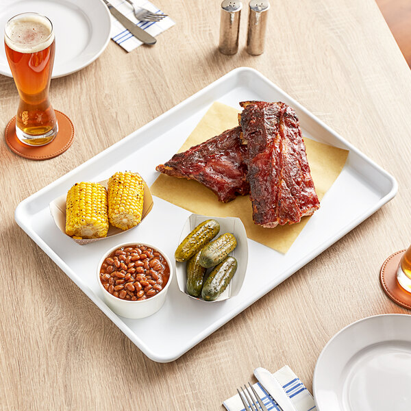 A Baker's Mark white non-stick aluminum sheet tray with ribs holding a plate of food and a bowl of beans.